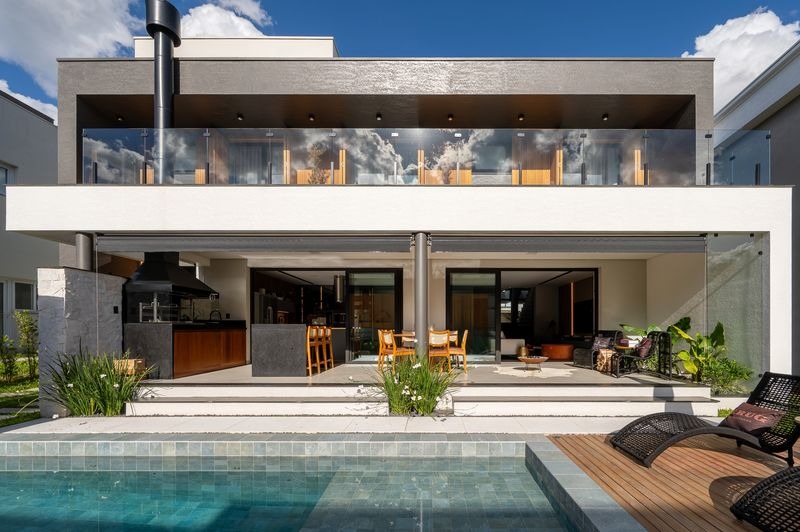Piscina com deck de madeira e área gourmet integrada