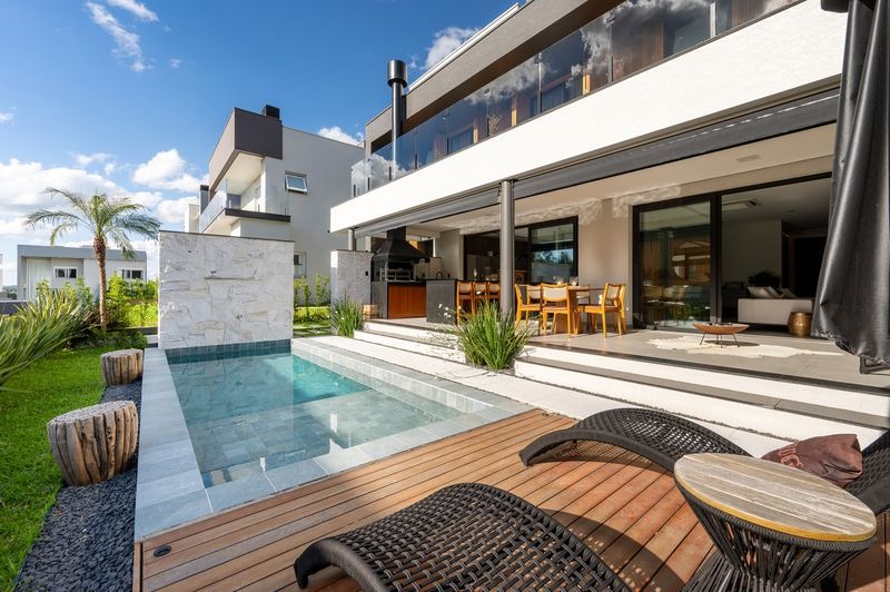 Piscina em concreto armado com deck e paisagismo